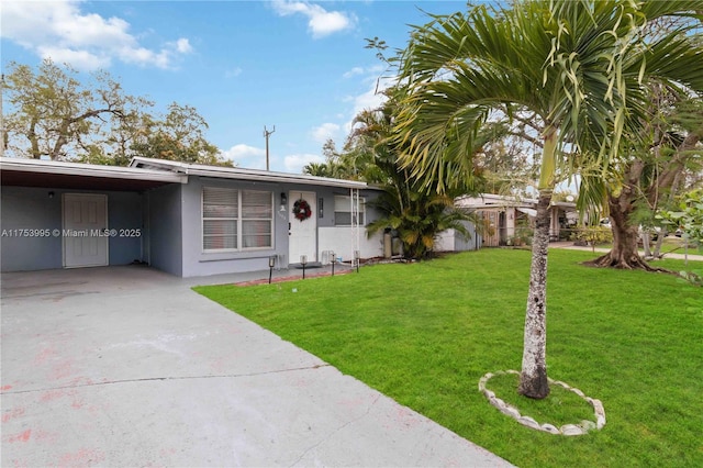 ranch-style home with a carport, a front yard, concrete driveway, and stucco siding