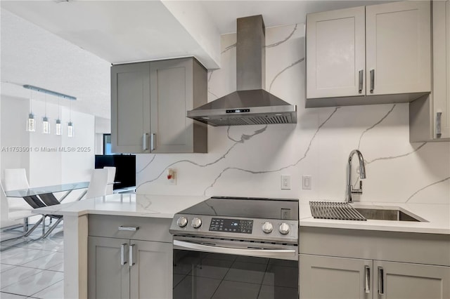 kitchen featuring gray cabinets, a sink, wall chimney exhaust hood, and stainless steel electric stove