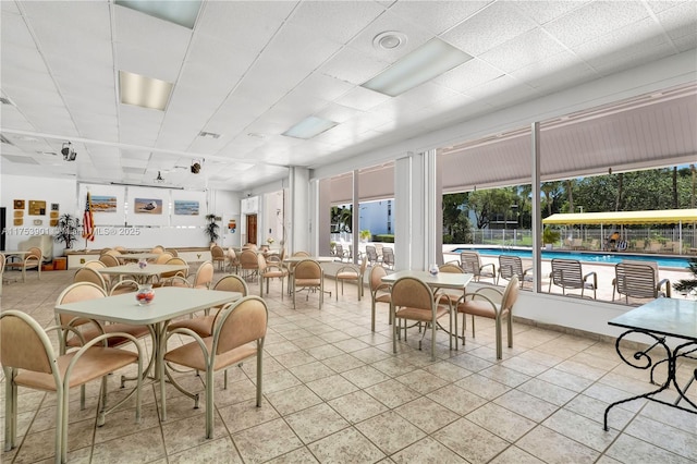 dining space featuring a paneled ceiling and light tile patterned floors