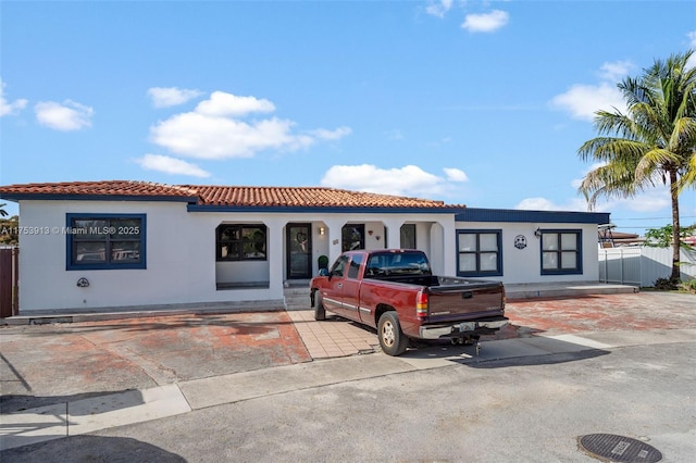 mediterranean / spanish home with a tile roof and stucco siding