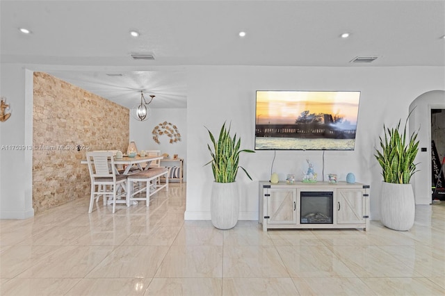 living room featuring arched walkways, marble finish floor, visible vents, and recessed lighting