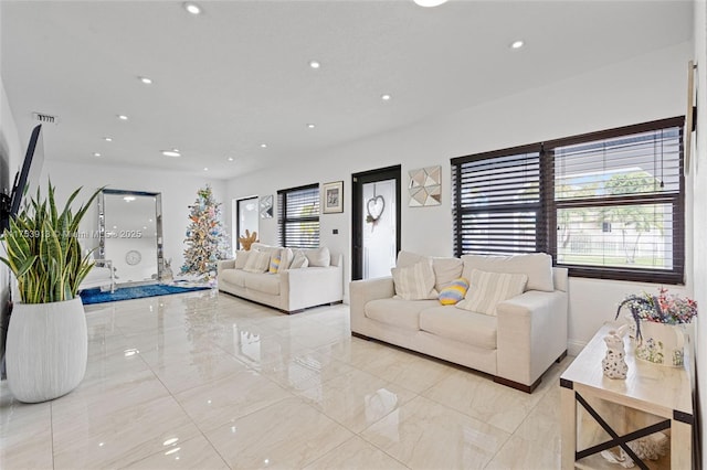 living area featuring recessed lighting, marble finish floor, and visible vents