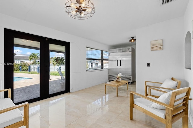 interior space featuring arched walkways, french doors, visible vents, and baseboards