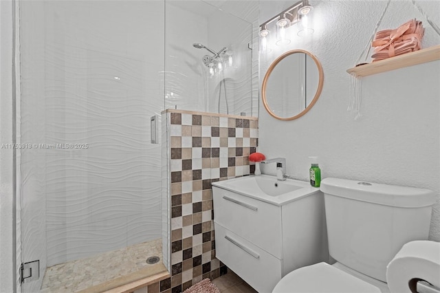 bathroom with a stall shower, vanity, and toilet