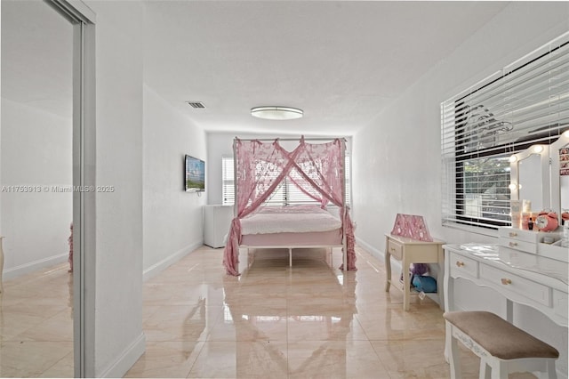 bedroom with multiple windows, visible vents, and baseboards