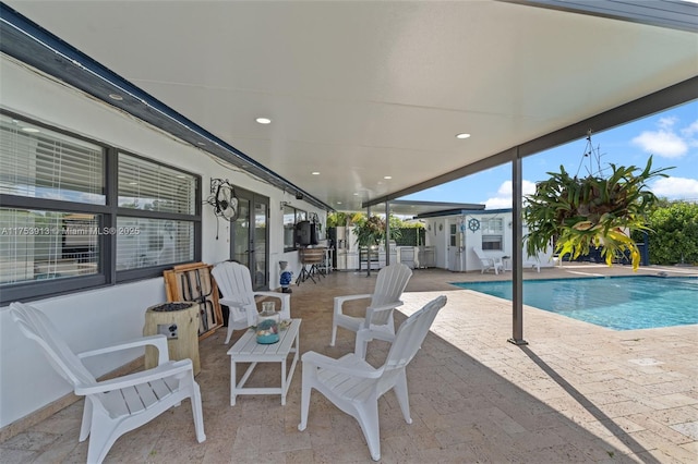 outdoor pool with french doors and a patio area