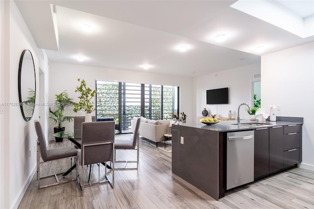 kitchen featuring light wood finished floors, a sink, dark brown cabinets, modern cabinets, and dishwasher