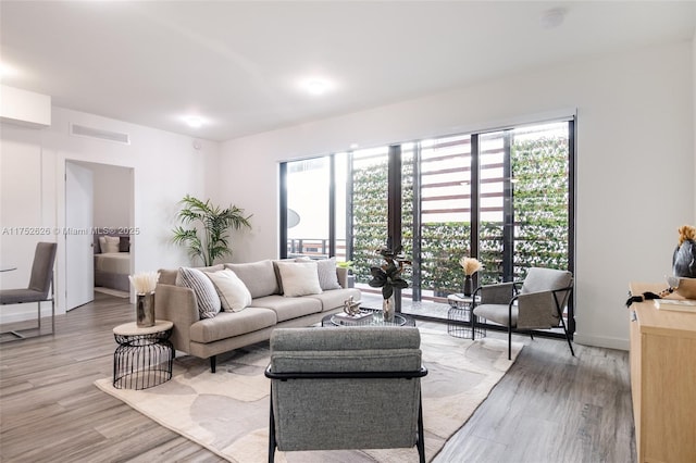 living room with visible vents and light wood-style flooring