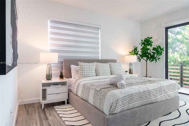 bedroom with access to outside, baseboards, and wood finished floors