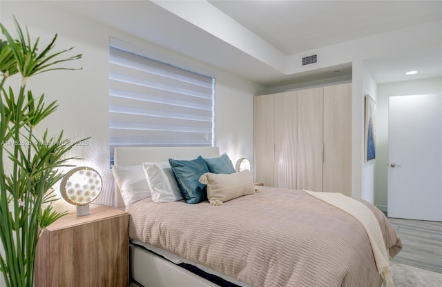 bedroom featuring light wood-type flooring, visible vents, and recessed lighting