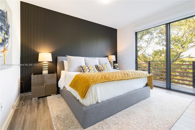 bedroom with access to outside, baseboards, and wood finished floors