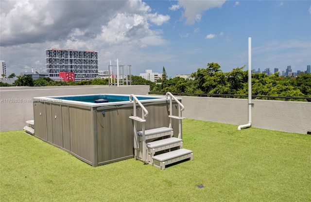 view of swimming pool with a view of city, a lawn, and a swimming pool