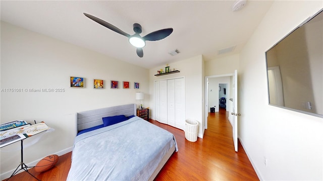 bedroom with a closet, wood finished floors, and visible vents