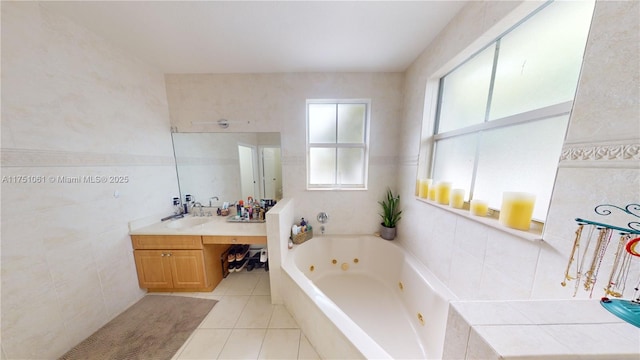 bathroom with a whirlpool tub, tile patterned flooring, vanity, and tile walls