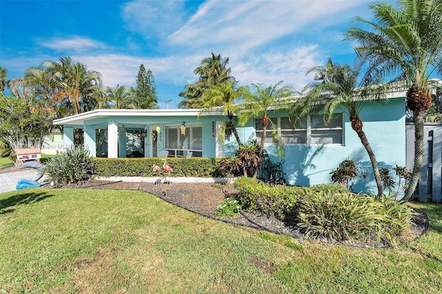 view of front facade with a front yard and stucco siding