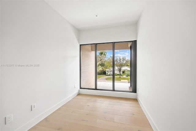 unfurnished room with light wood finished floors and baseboards