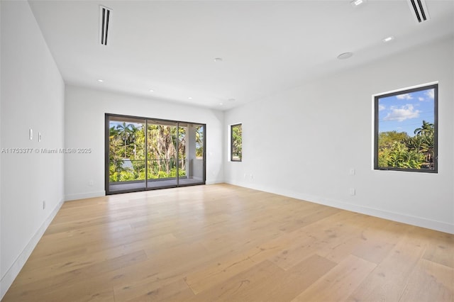 spare room featuring light wood-style floors, recessed lighting, visible vents, and baseboards