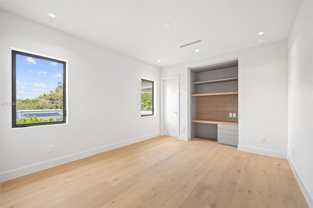 unfurnished bedroom with visible vents, baseboards, built in study area, light wood-style floors, and recessed lighting