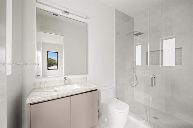 bathroom with a stall shower, vanity, and toilet