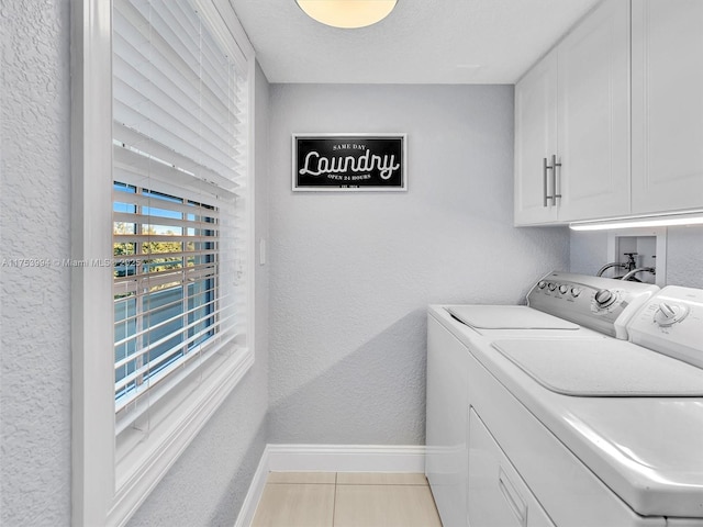 clothes washing area with a textured wall, cabinet space, independent washer and dryer, and baseboards