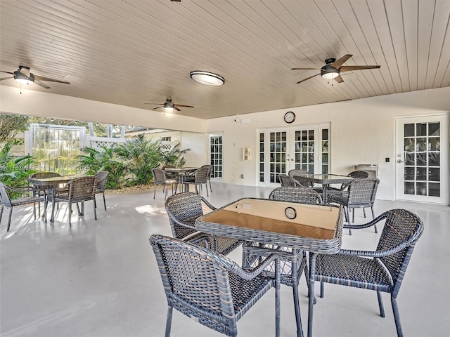 view of patio with a ceiling fan, outdoor dining area, and french doors