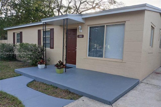 doorway to property featuring stucco siding