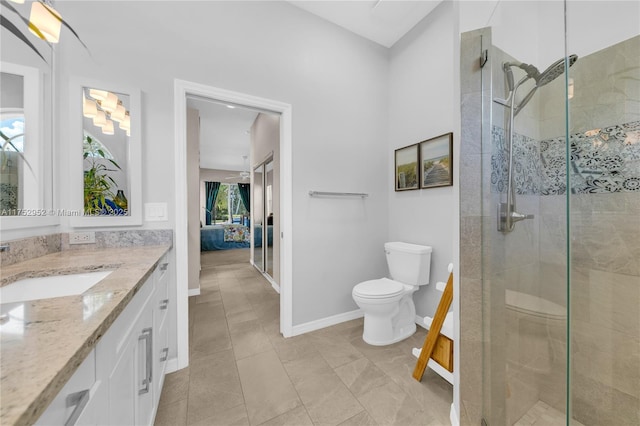 ensuite bathroom featuring a stall shower, baseboards, connected bathroom, toilet, and vanity