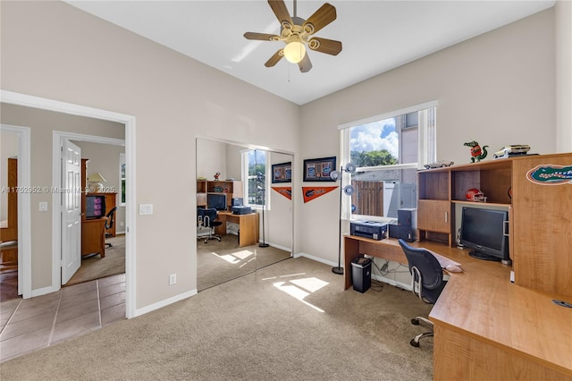 home office with ceiling fan, tile patterned flooring, baseboards, vaulted ceiling, and carpet