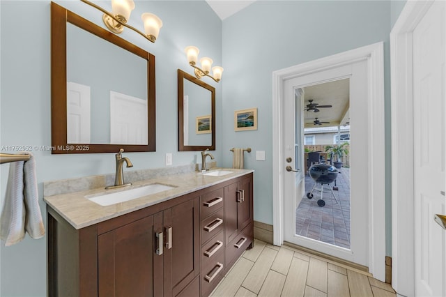 bathroom featuring ceiling fan, wood tiled floor, a sink, and double vanity