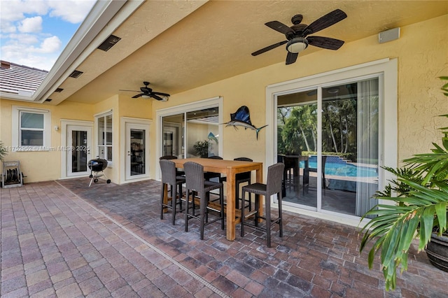 view of patio featuring ceiling fan, visible vents, grilling area, and outdoor dining space