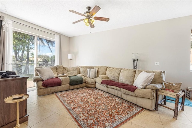 living room with a ceiling fan, a textured ceiling, and light tile patterned flooring