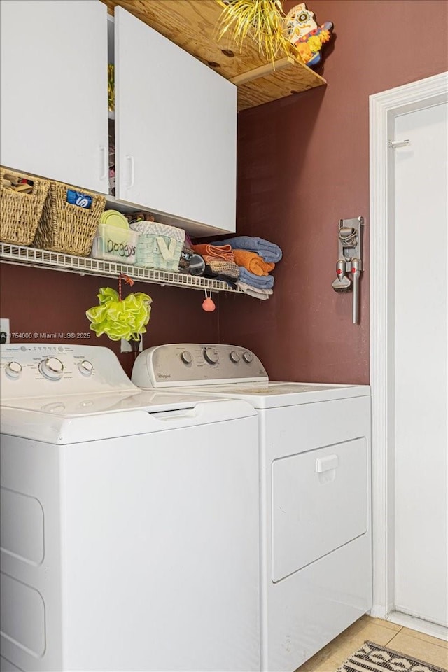 washroom featuring cabinet space, light tile patterned flooring, and independent washer and dryer