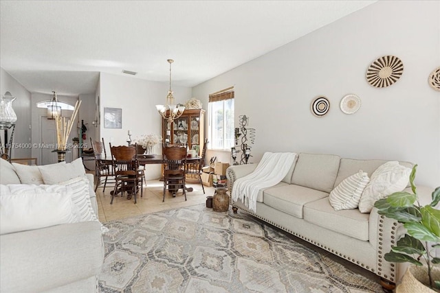 living area featuring a chandelier, stairway, light tile patterned flooring, and visible vents