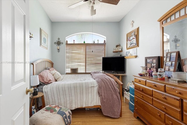 bedroom with a textured ceiling, a ceiling fan, and wood finished floors