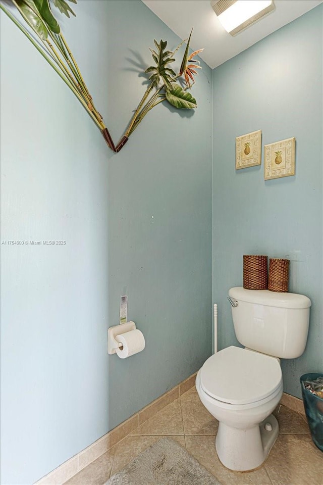 bathroom featuring tile patterned flooring, toilet, and baseboards