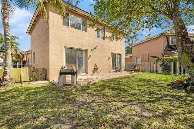 rear view of house with a patio area, a fenced backyard, a lawn, and stucco siding