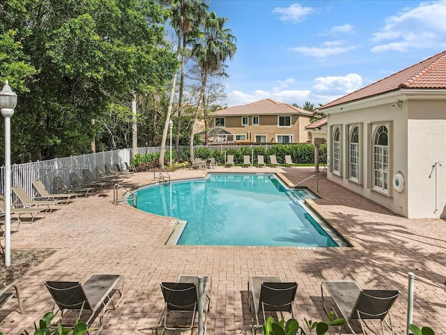 pool with fence and a patio