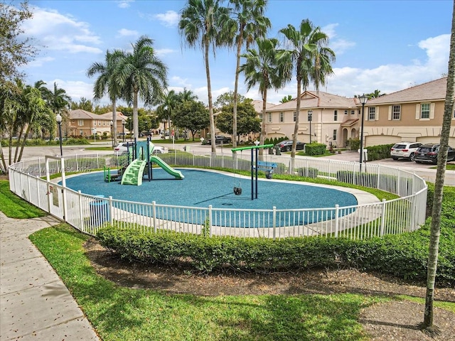 communal playground featuring a residential view and fence