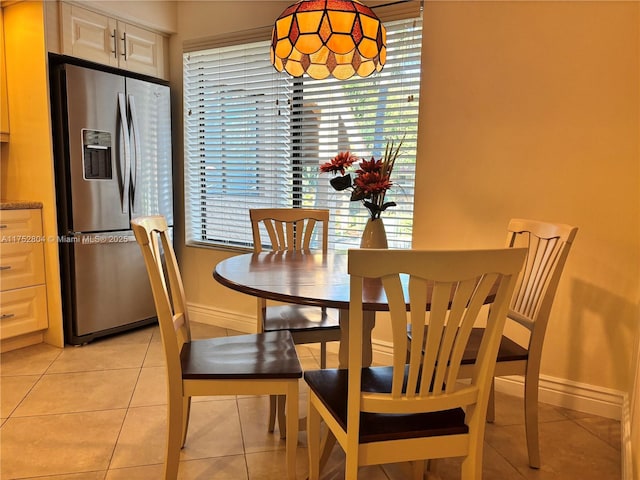 dining space with light tile patterned floors and baseboards