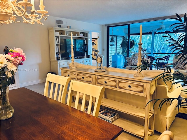 tiled dining space with a chandelier, a textured ceiling, visible vents, and baseboards