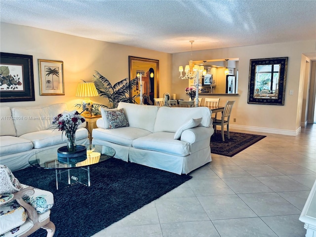 tiled living room featuring baseboards, a chandelier, and a textured ceiling