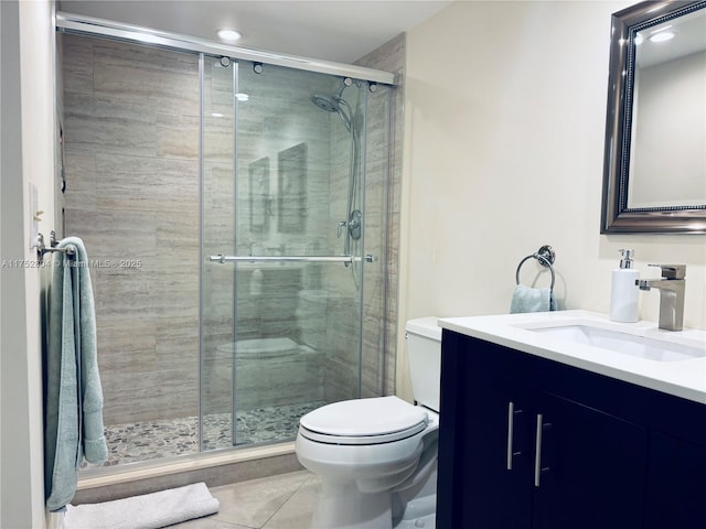 full bath featuring vanity, a shower stall, toilet, and tile patterned floors