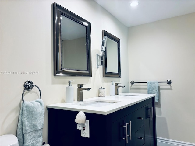 bathroom featuring toilet, vanity, and recessed lighting