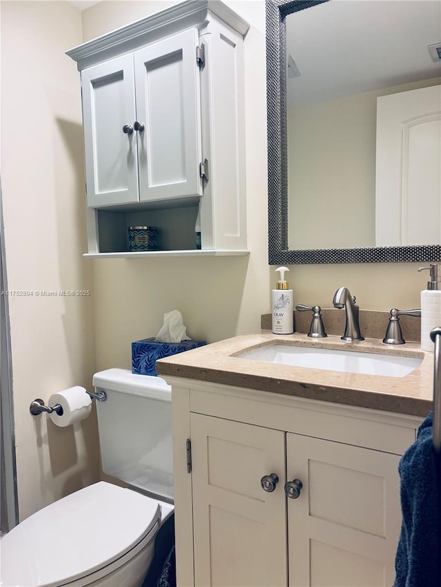 half bathroom with vanity and toilet