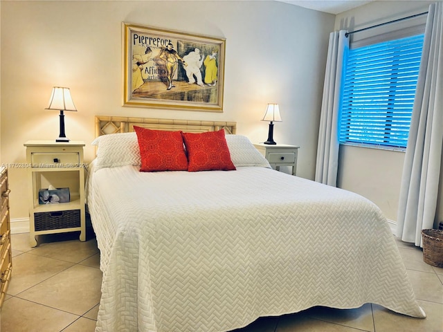 bedroom with light tile patterned flooring and baseboards