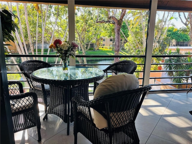 sunroom / solarium featuring a water view