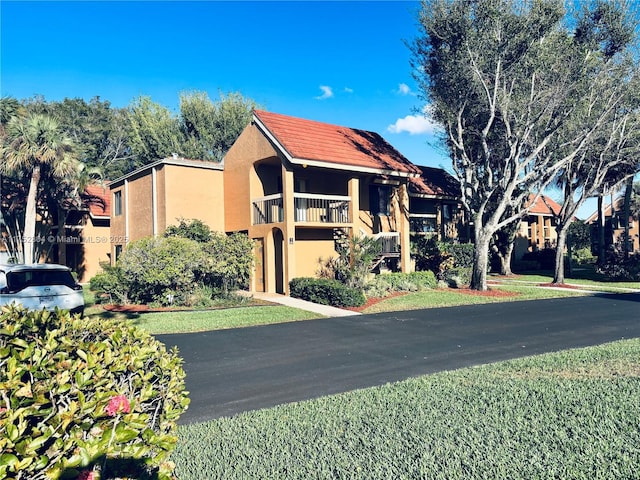 view of front of house featuring a balcony and stucco siding