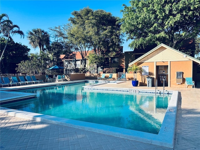 community pool with a patio area and fence