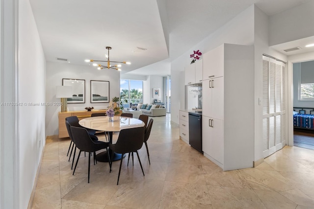 dining room with baseboards, visible vents, and an inviting chandelier