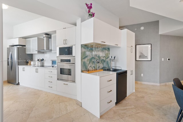 kitchen with wall chimney exhaust hood, stainless steel appliances, light countertops, white cabinets, and baseboards